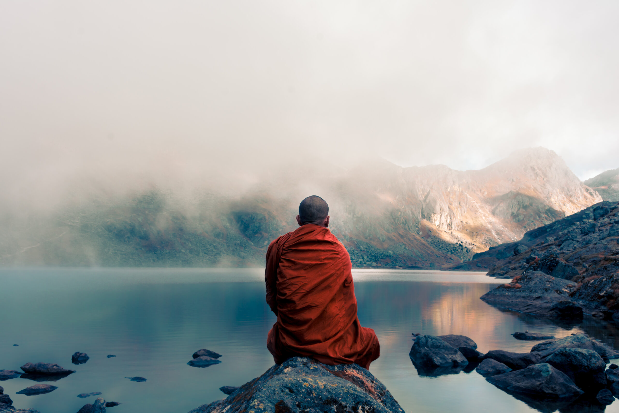 A,Tibetan,Monk,From,Back,Sitting,On,The,Stone,Near